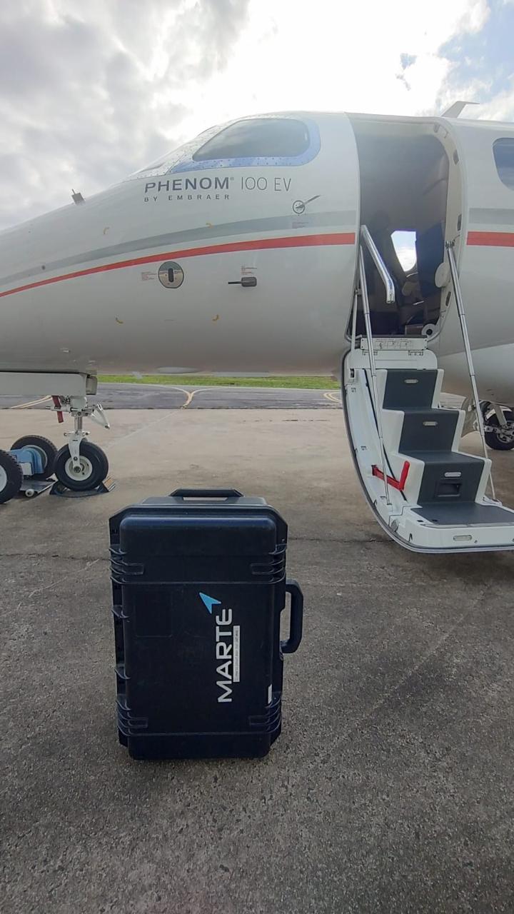 Maleta de equipamentos da Marte Updates ao lado de um Phenom 100 EV