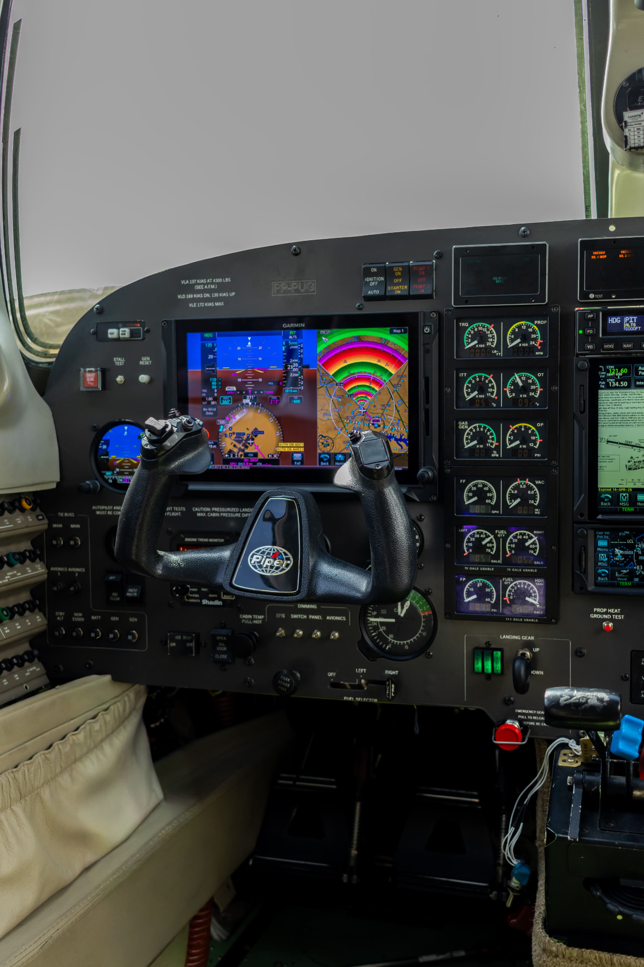 Lado do comandante com tela primária de voo Garmin